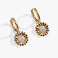 Close up of gold-toned Sunflower Huggie Hoop Earrings reflecting light.