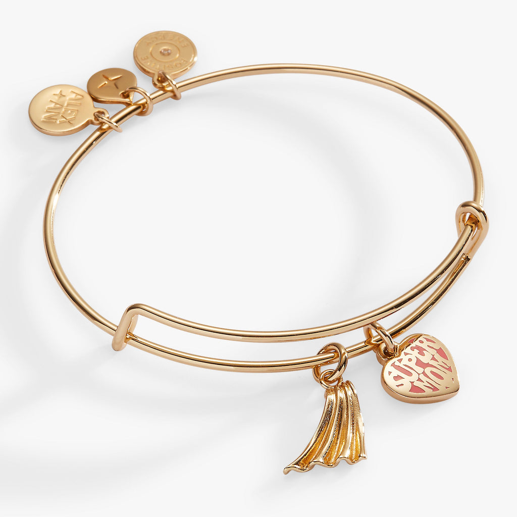 Gold expandable wire bangle featuring an enamel heart charm saying Super Mom and a gold superhero cape charm.
