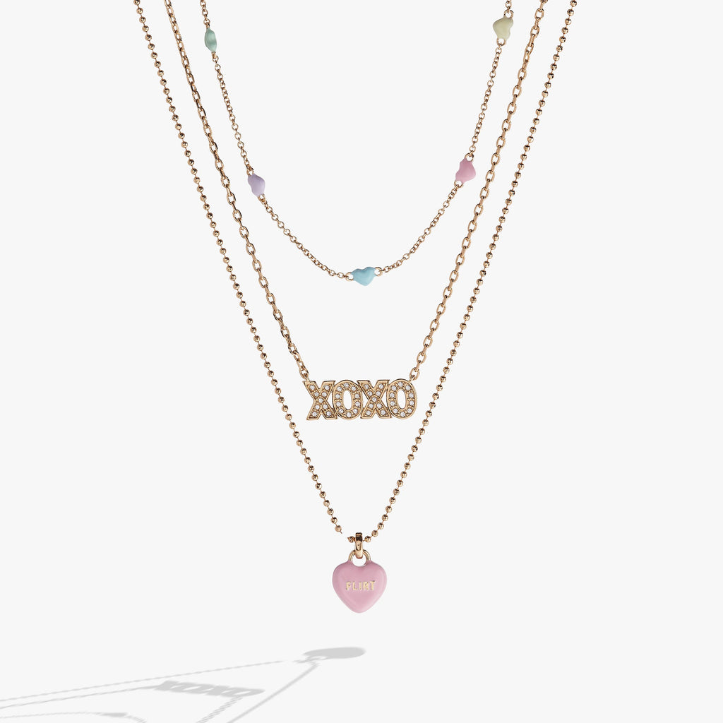 Triple-strand gold-tone necklace featuring inline multicolored heart crystals