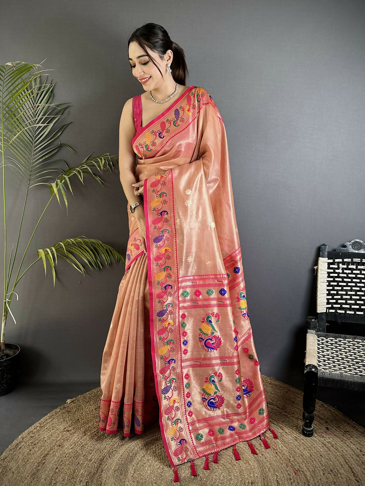 A dark peach tissue Paithani saree with elaborate gold zari weaving and a matching blouse.