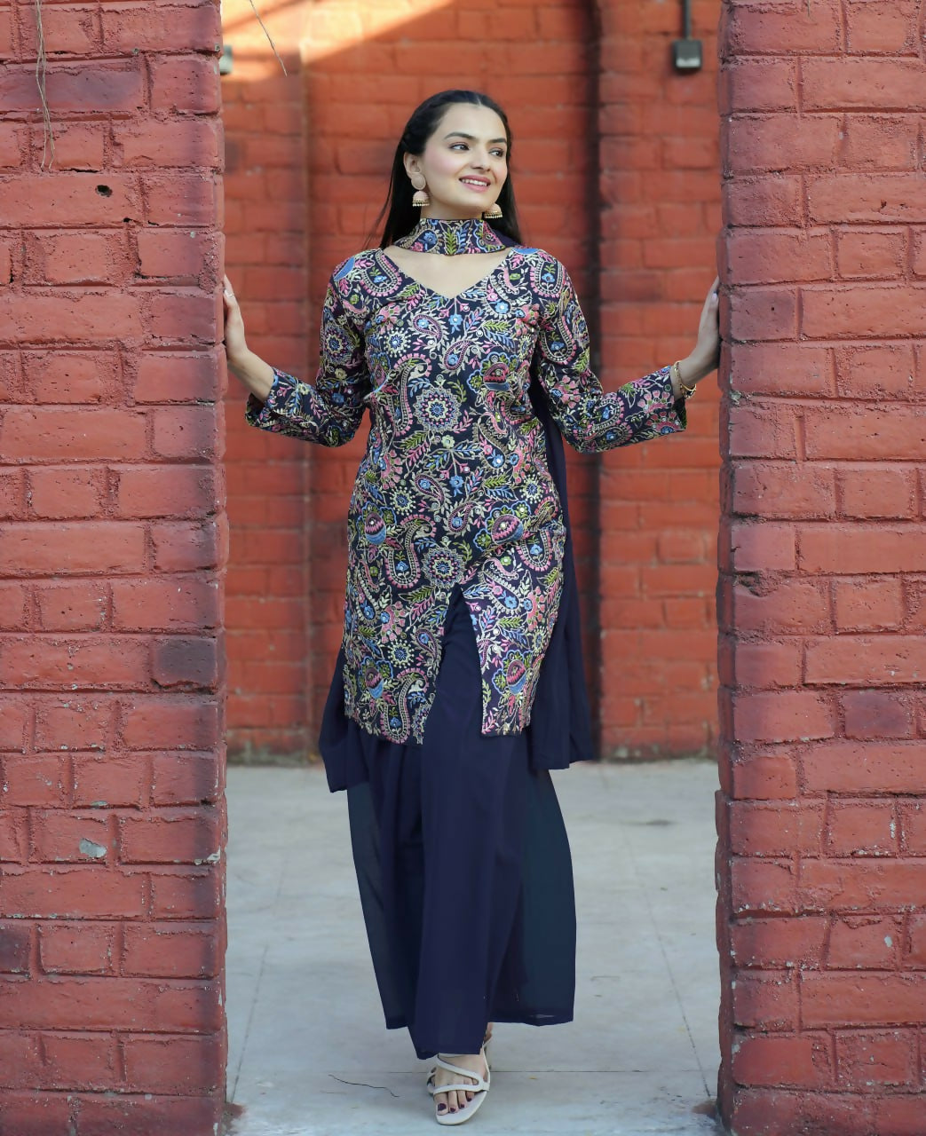 Model wearing a blue silk embroidered kurti with matching sharara pants