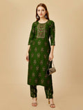 Women wearing a green embroidered straight kurta pant set in viscose rayon.
