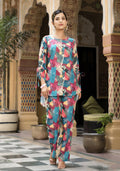 A woman wearing a vibrant multi-colored muslin bohemian co-ord set with abstract print, featuring high-low hem top and straight-cut pants.