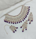 Purple stone necklace set with pearl accents, including earrings and tikka