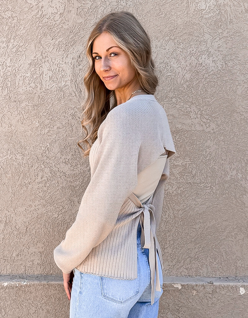 Long sleeve beige ribbed sweater featuring an elegant open back design