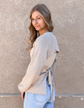 Long sleeve beige ribbed sweater featuring an elegant open back design