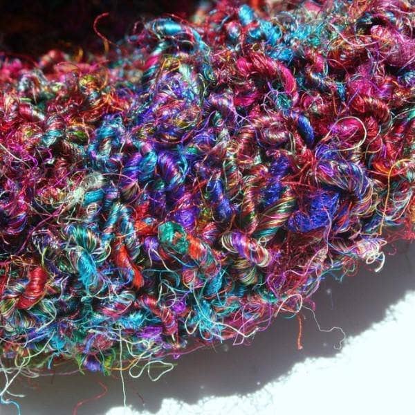 Darn Good Accessory knitting kit featuring yarn in magenta, cobalt-blue, teal, and purple.