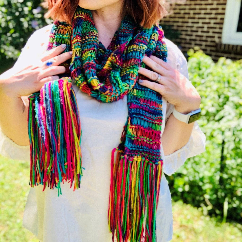 Close-up of a vibrant, multi-colored knit Iris scarf with drawstring detail and rich texture.