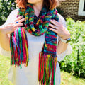 Close-up of a vibrant, multi-colored knit Iris scarf with drawstring detail and rich texture.
