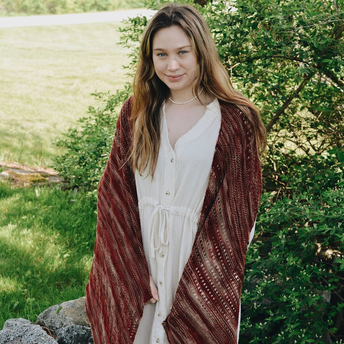 Close up of the Madeleine Shawl featuring various intricate stitch patterns and earthy color tones.
