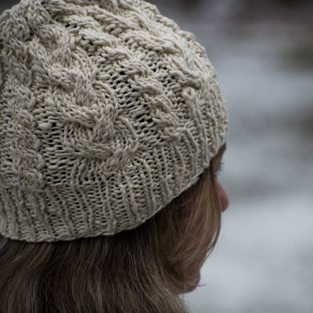 Close-up of the Magnolia Winter Knit Beanie showing detailed cable knit texture and soft silk yarn.