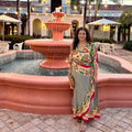 Model wearing a vibrant, multi-colored silk wrap maxi dress in an abstract pattern with three-quarter sleeves.