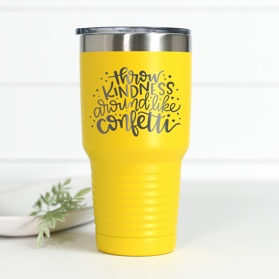 Bright yellow 30 oz stainless steel tumbler with the text 'Throw Kindness Like Confetti' laser engraved in the center.