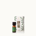 Amber glass bottle of Frasier Fir diffuser oil on a white background with green accents
