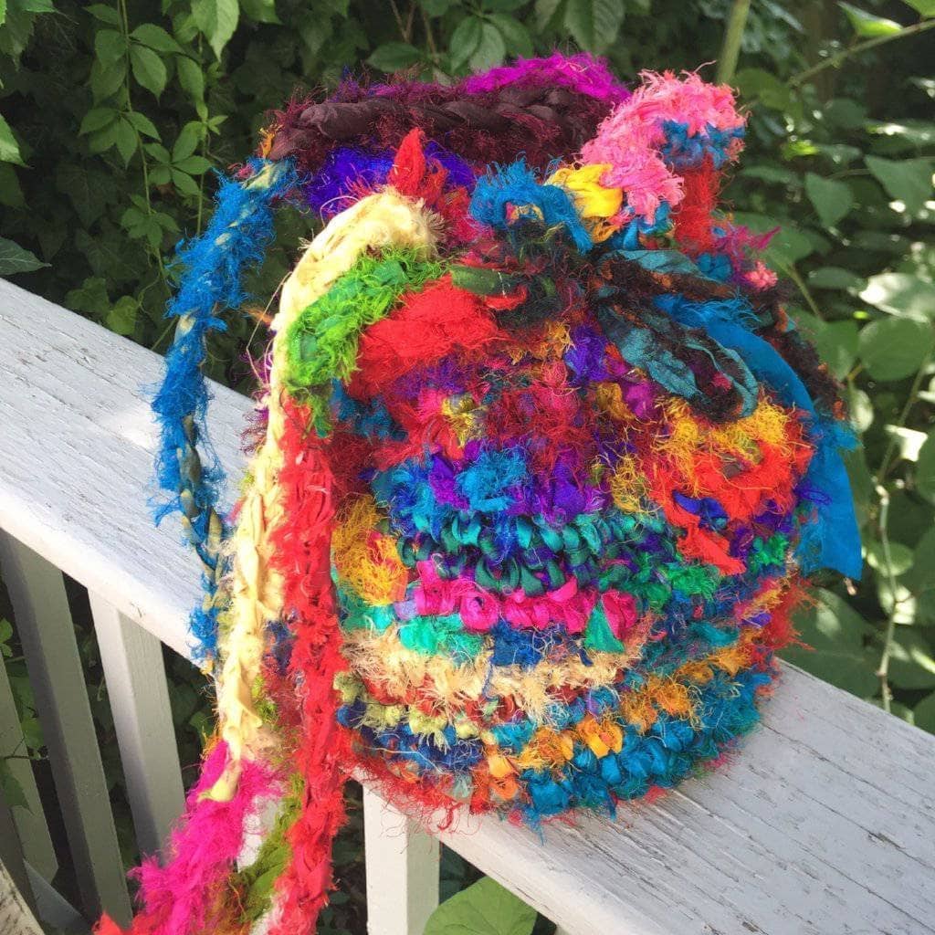 A vibrant, multicolored crochet bucket bag made from recycled sari silk yarn.