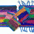 Close up of woven Tibet Jewels coasters and trivets featuring vibrant silk ribbon yarn texture.