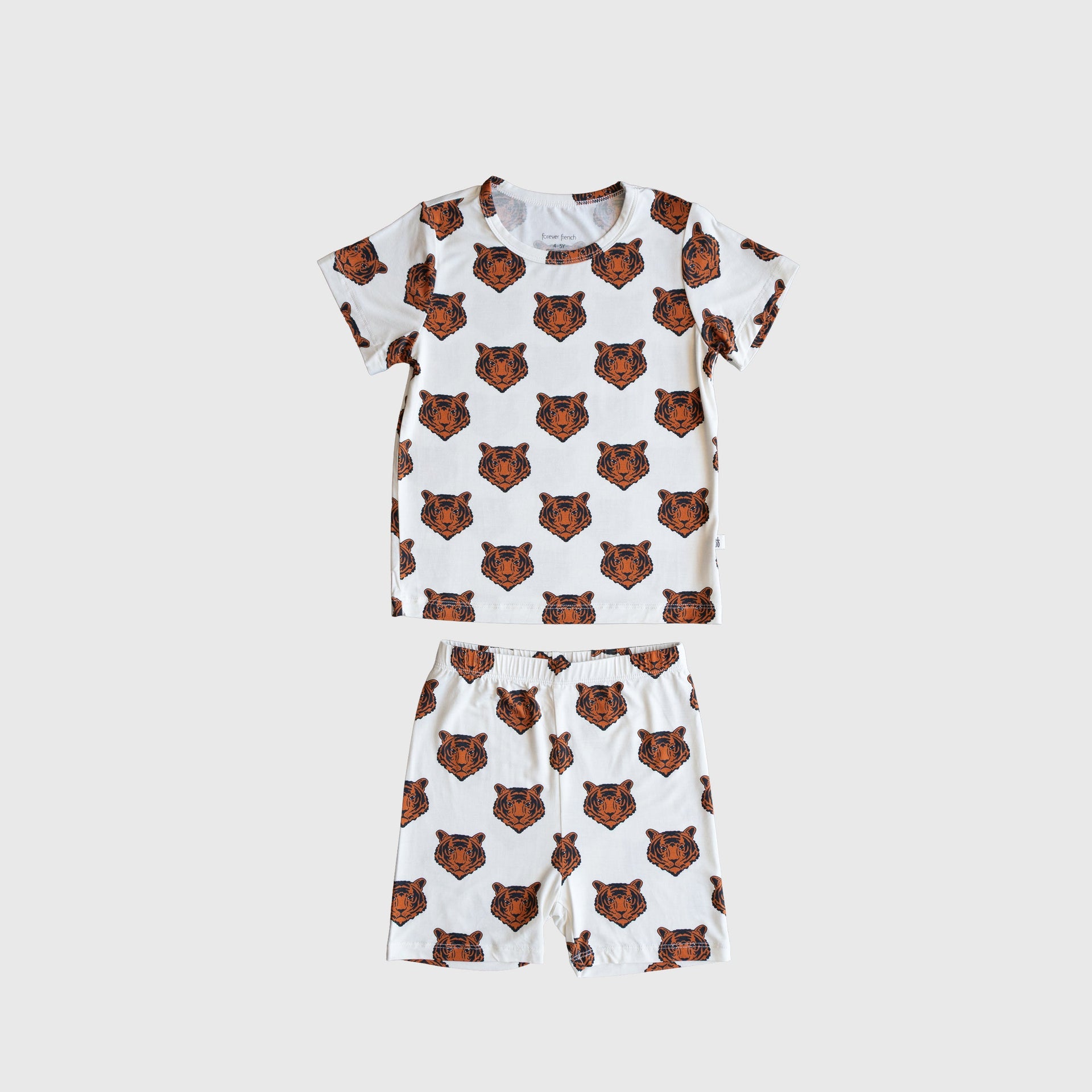 Child wearing a white and orange tiger print bamboo short set with biker style shorts