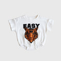Baby wearing a short sleeve cotton romper in white, orange, and black, featuring snap closures.