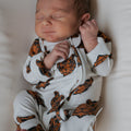 Close up of premium bamboo zip pajamas for kids featuring an orange and black tiger print.