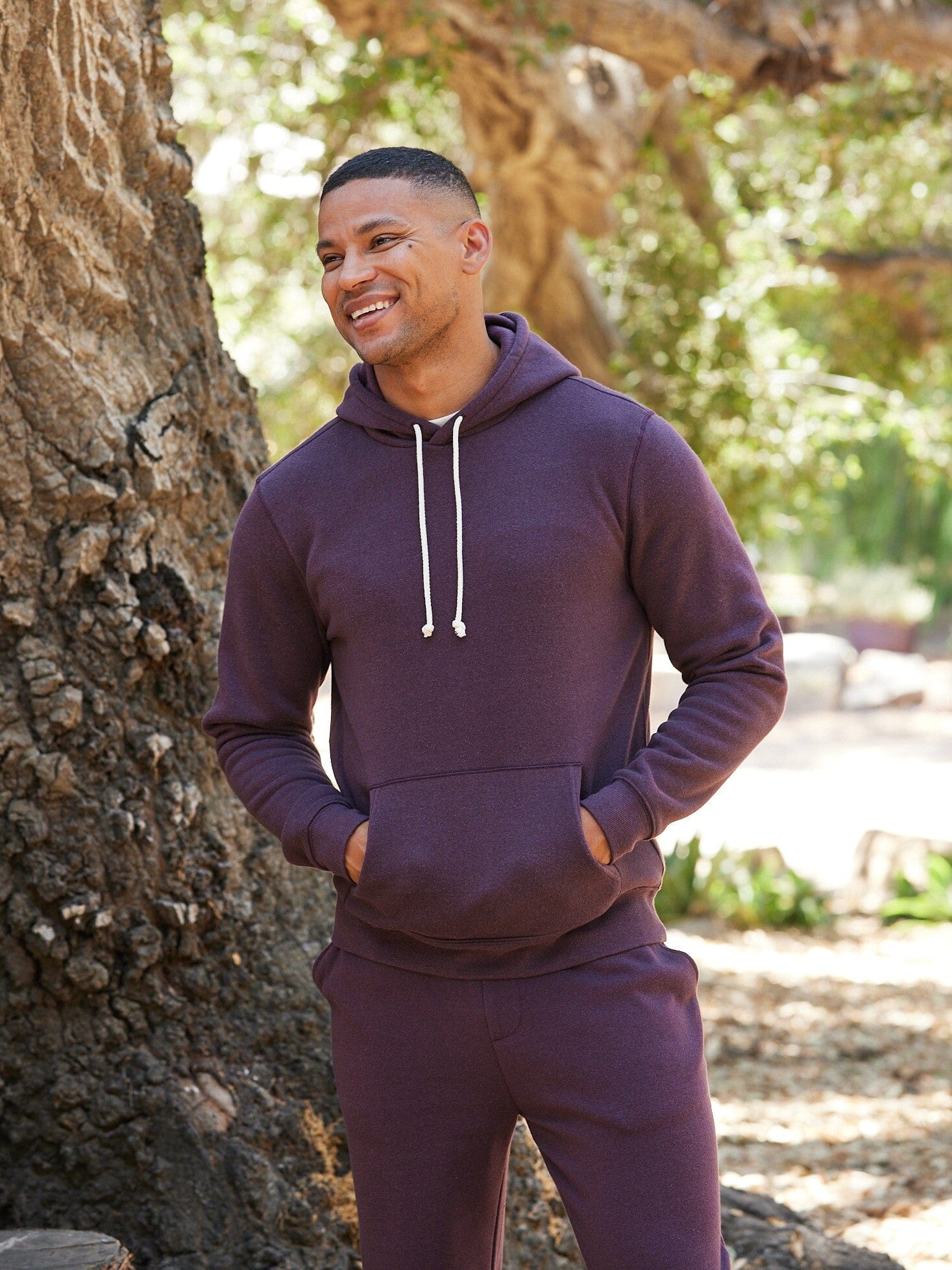 Men wearing a soft triblend fleece pullover hoodie with an adjustable drawcord hood and kangaroo pocket