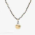 Toile Beaded Palm Pendant Necklace featuring black and white glass beads and a satin gold palm frond pendant