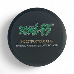 A 3.4oz container of Tomb 45 Indestructible Hair Styling Clay with a matte finish label.