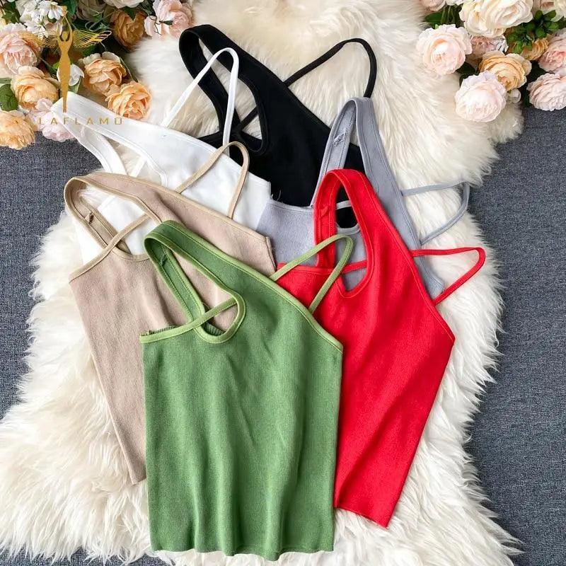 A woman wearing a minimalist sleeveless knit crop top with a cross-front detail in a solid color.