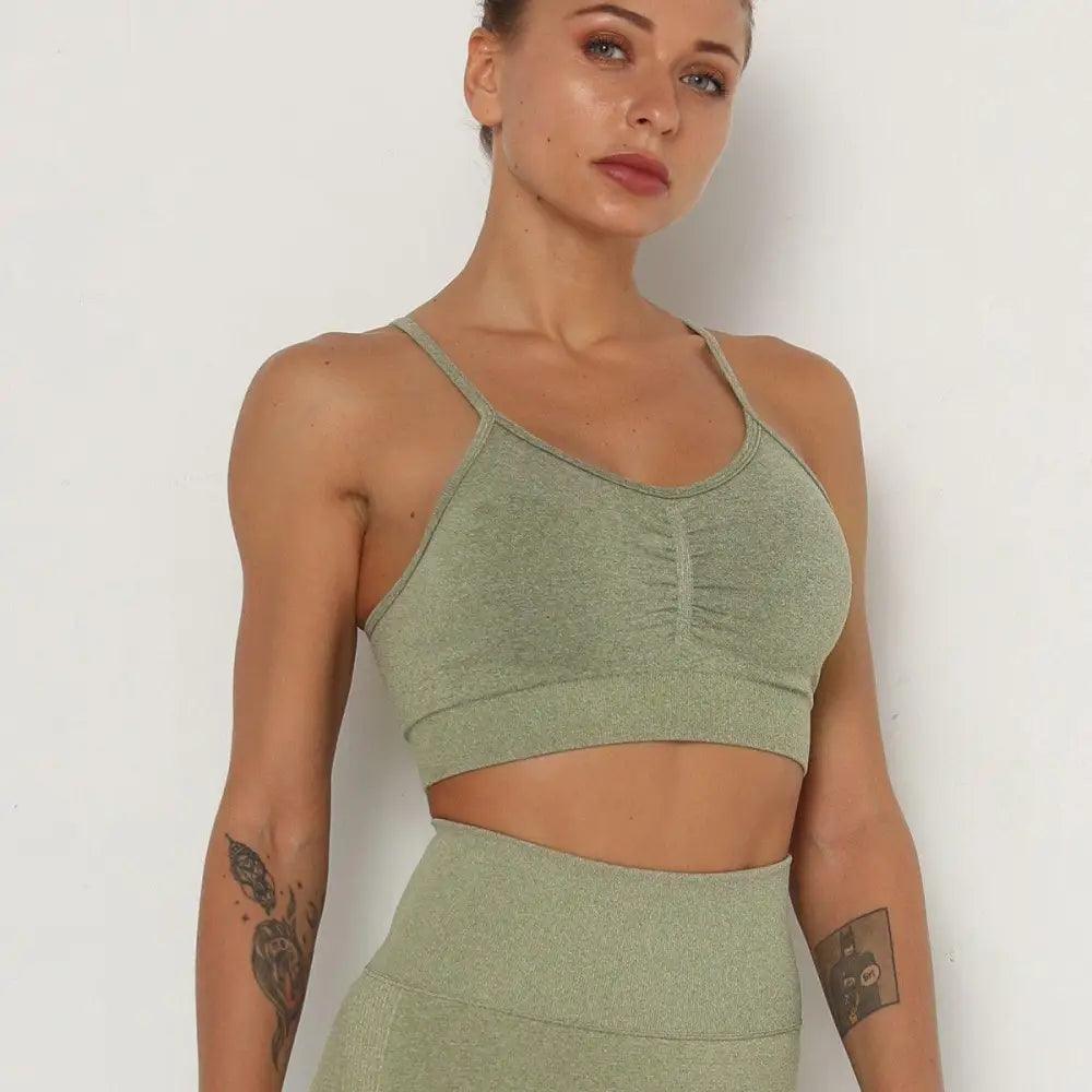 Woman wearing a seamless, fitted cropped sports bra with scoop neckline in heathered athletic color