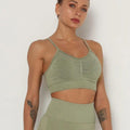Woman wearing a seamless, fitted cropped sports bra with scoop neckline in heathered athletic color