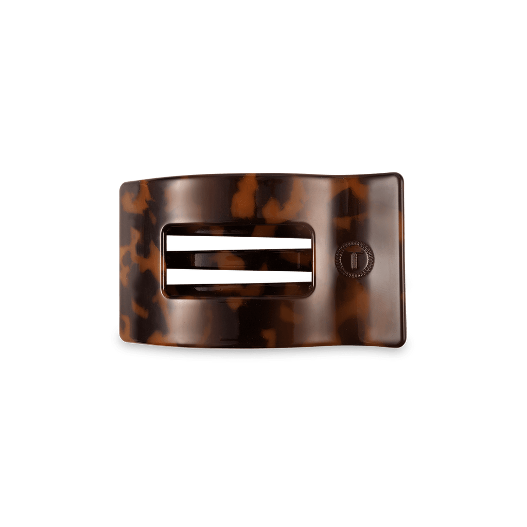 Small rectangular hair clip in a classic tortoise shell pattern resting on a flat surface