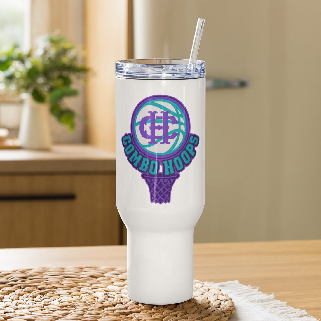 White travel tumbler with a basketball themed Nh Combo Hoops logo on the front sitting on a woven placemat