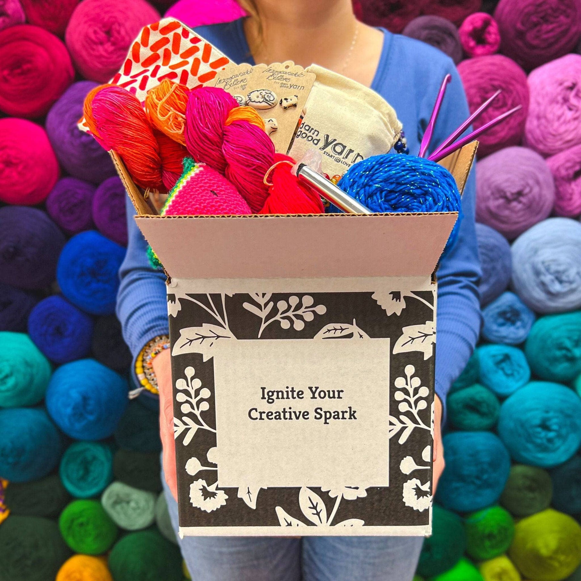 A curated collection of colorful, premium yarns inside a Darn Good Yarn Editor's Box craft supply kit.
