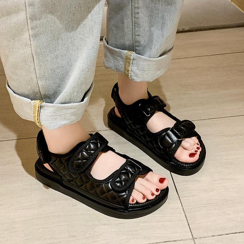 Trendy black women's flat hiking sandals with adjustable straps and thick soles for outdoor activities.