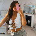 A woman wearing a black and white patchwork Y2K-style hollow-out lace-up crop tank top