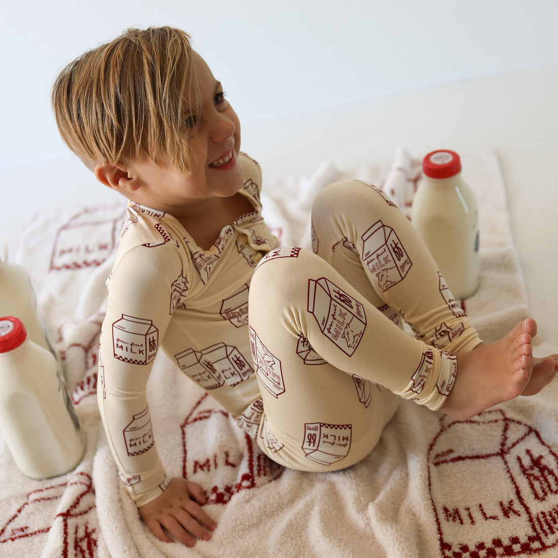 Child wearing a two-piece bamboo pajama set with a milk carton pattern.