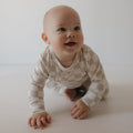 Child wearing a beige and cream geometric checkerboard footless lounge set.