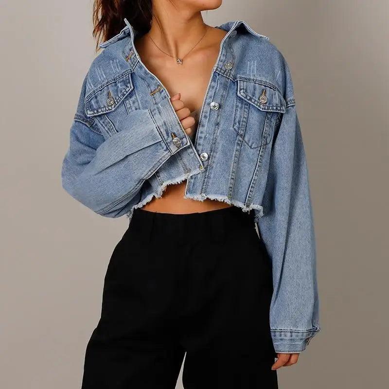 Stylish women's cropped denim jacket with distressed details and flap pockets in blue.
