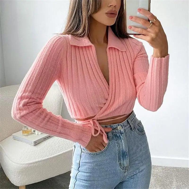 Pink V-neck sweater featuring a lace-up bow detail on the neckline.