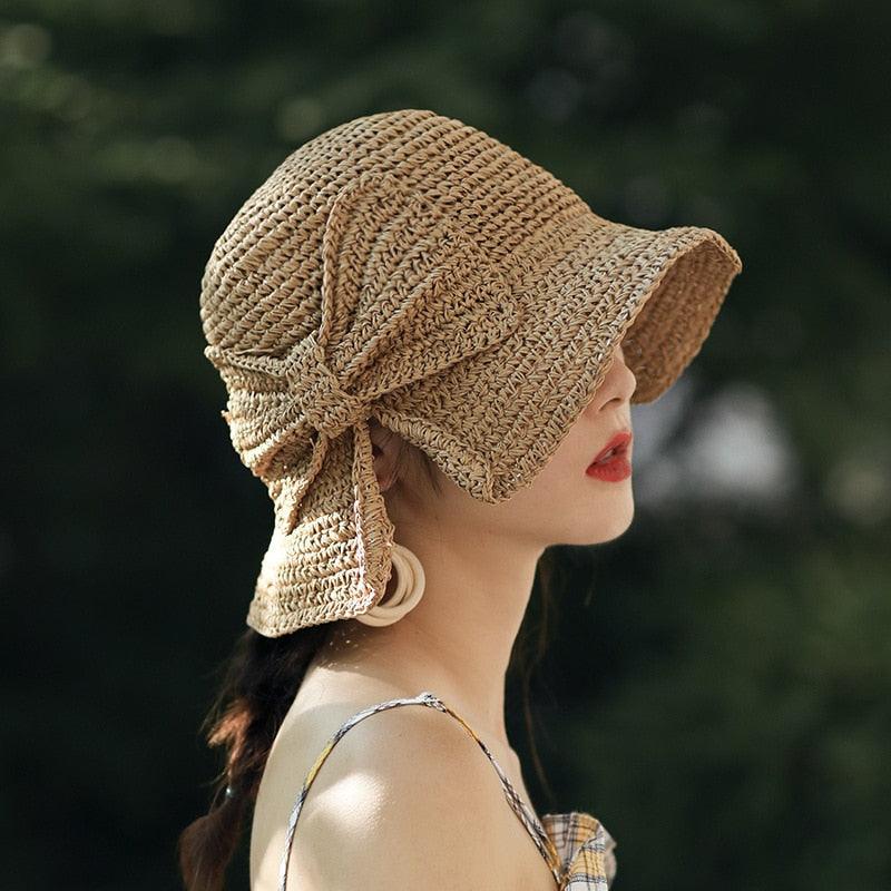 Foldable women's straw sun hat with a decorative bow, ideal for beach and summer travel