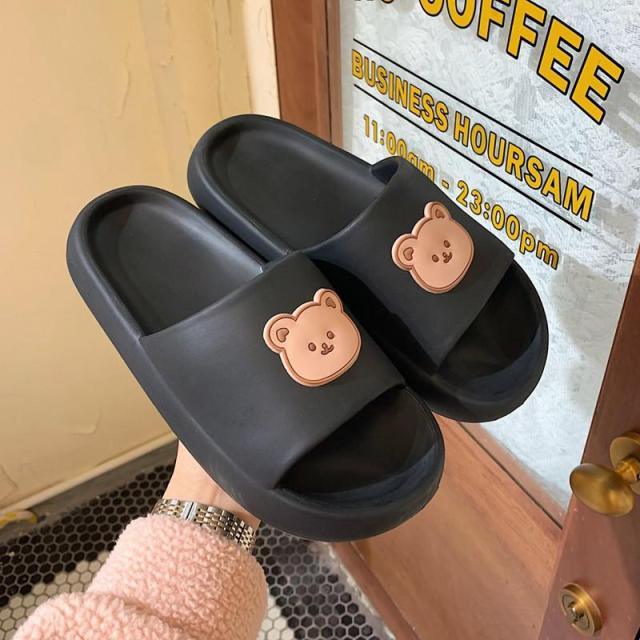A pair of unisex thick-soled bear design beach slides in an open-toe, slip-on style.
