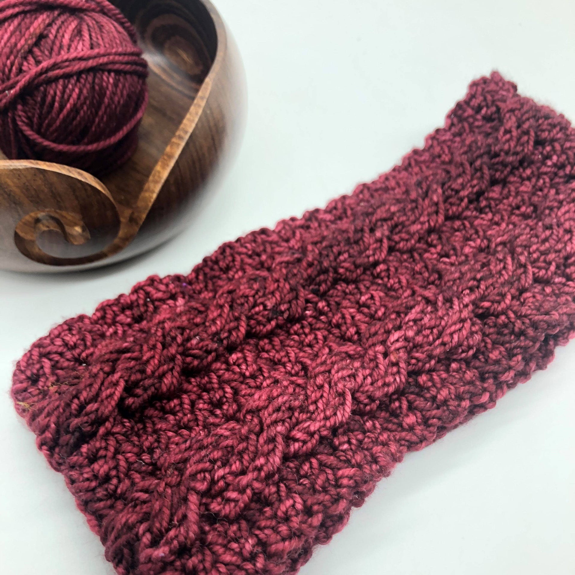Twin cable crochet headband in deep burgundy knit material styled for winter