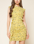 Model wearing a yellow and blue floral print sleeveless ruched mini dress with an open back.