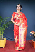 Traditional red Paithani silk saree with elegant Zari woven patterns and matching blouse.