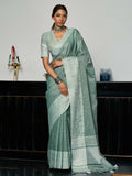 Sea green woven linen saree with gold zari border and decorative tassels
