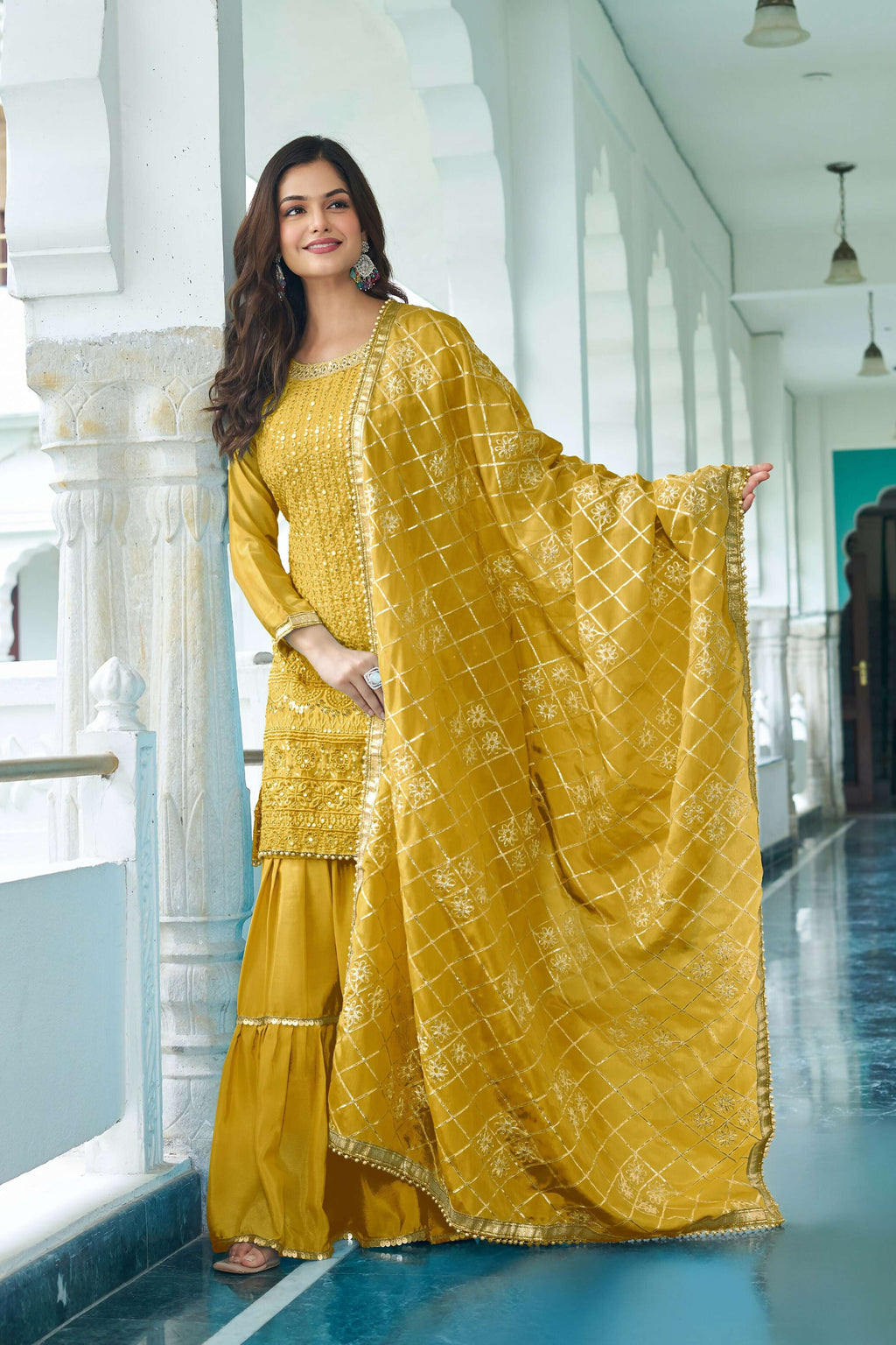 Woman wearing a Yellow Chinon Silk Kurta Set with detailed embroidery and sequence work