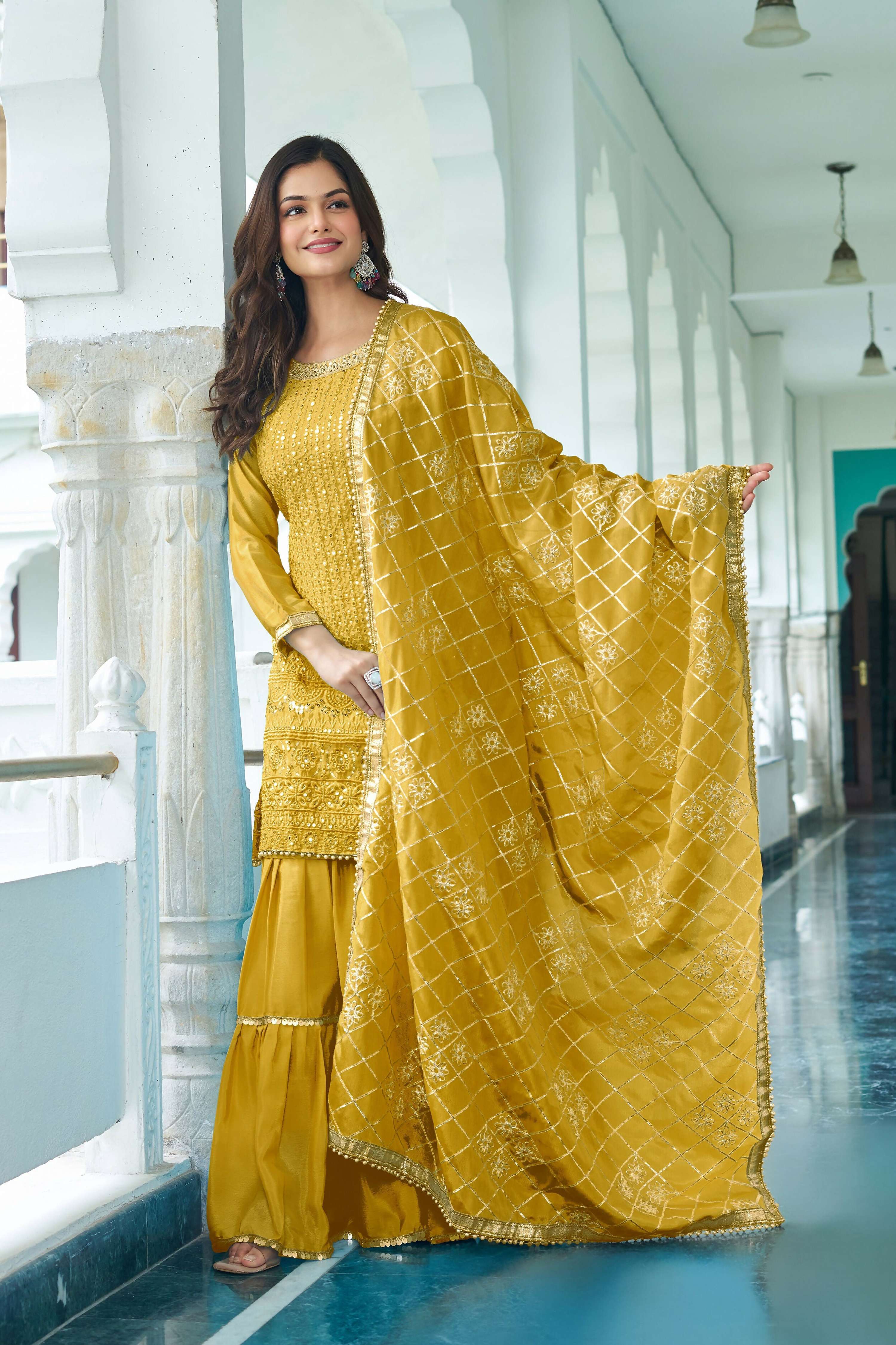 Woman wearing a Yellow Chinon Silk Kurta Set with detailed embroidery and sequence work