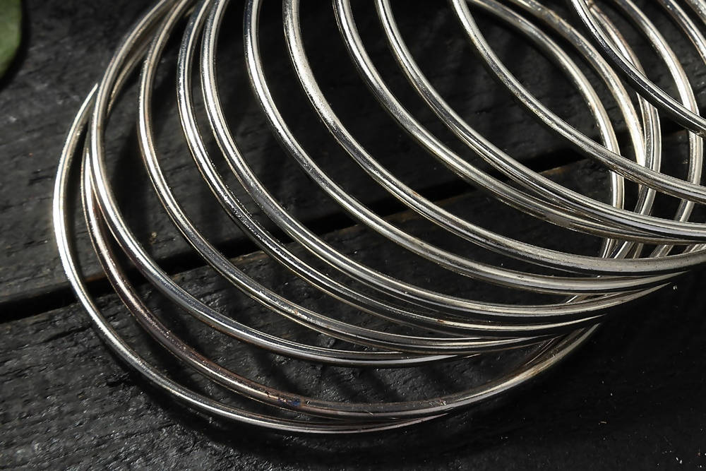 Intricate oxidised alloy silver bangles set on display