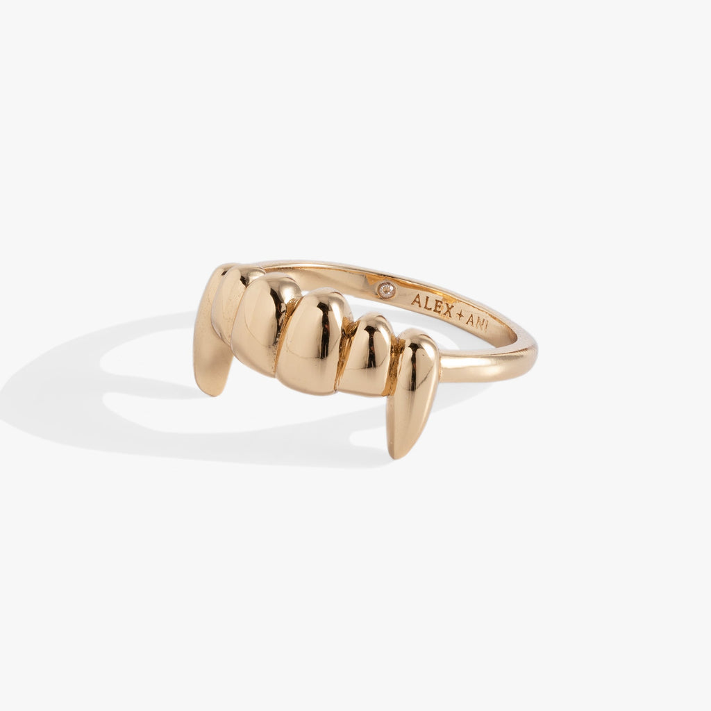 Close up of a modern Vampire Teeth Fangs ring in gold and silver, featuring a 2cm motif worn on a finger.
