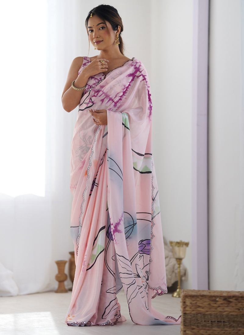 Baby girl wearing a baby pink Chinon silk designer saree with a glittery mirror-work border for a festive look.