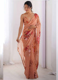 Close up of peach georgette silk saree with intricate printed patterns and a beaded moti work border.